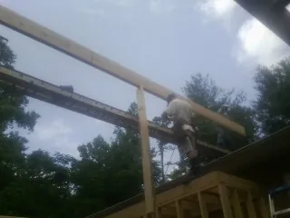 Carpenter setting a ridge beam over a new addition frame — Ice Dam Removal by Roofing Brothers in Maybrook