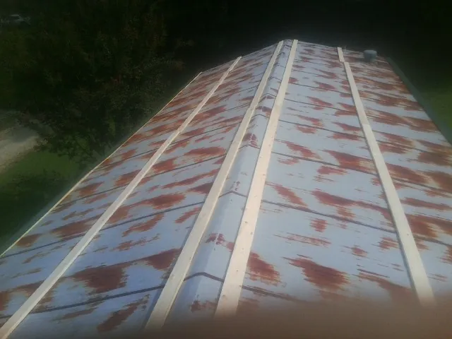 Rusted metal roof panels with new wood purlins before replacement — Storm Damage Roof Repair in Maybrook by Roofing Brothers