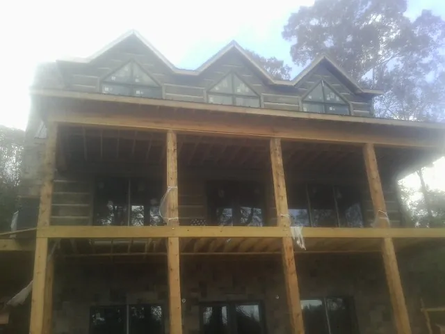 Dormers and porch framing on a large log home under construction — Roof Coating work by our crew in Maybrook