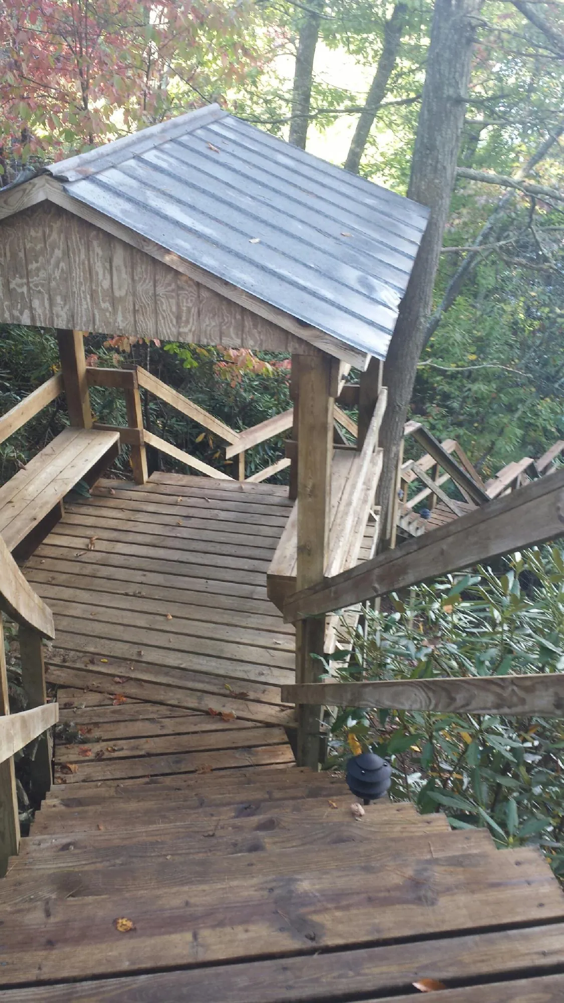 Metal roofed shelter over wooden steps on a wooded walkway — Skylight Repair & Installation work by our crew in Maybrook