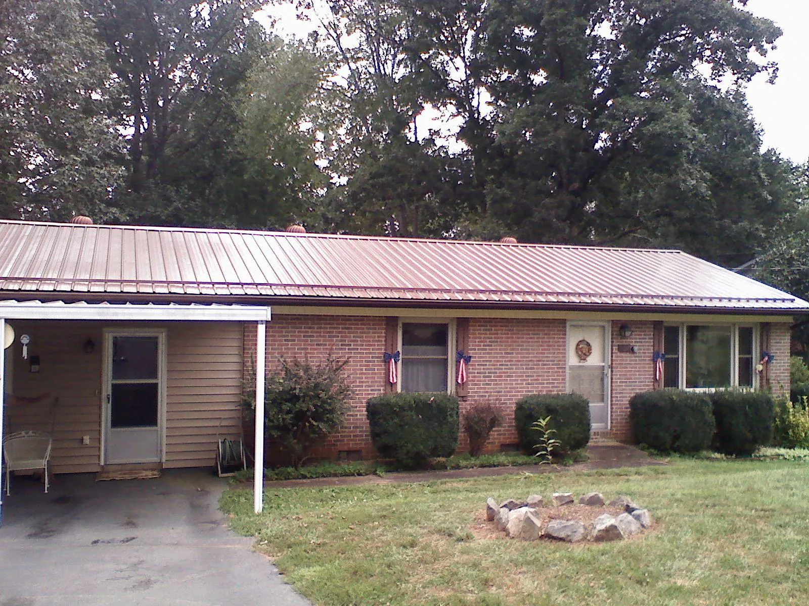 Bronze metal roof and carport on a brick ranch home — Roof Repair work by our crew in Maybrook